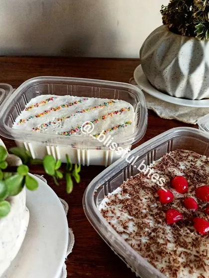 My Mixed Fruit Soufflé in convenient takeaway containers. One is topped with colourful sprinkles and the other with cherries and chocolate shavings.