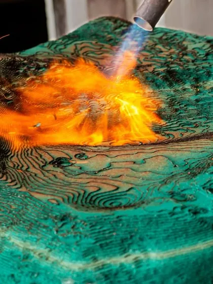 We often collaborate with skilled artisans to create unique design elements. This image shows the forging process for the textured metal panels of the Soaltee Hotel's mountain wall, using fire to shape and imbue the material with a raw, organic quality.