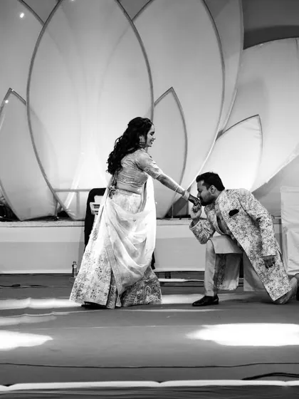 A romantic gesture on stage, captured in timeless black and white with dramatic lighting.