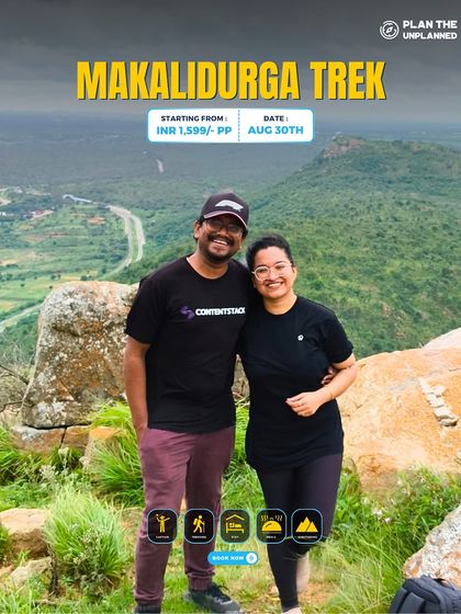 A couple smiles for a photo on the Makalidurga trek, with the vast landscape behind them. This one-day trek near Bangalore is perfect for a quick and scenic escape.