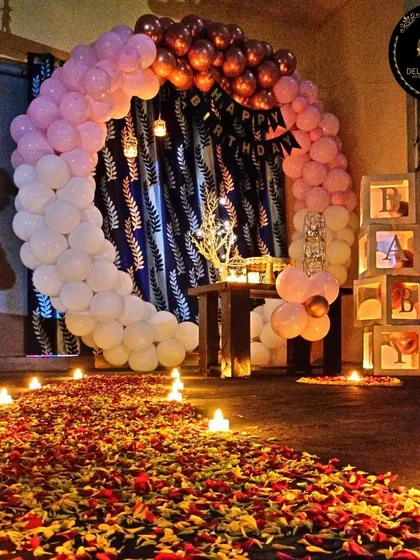 We set the stage for romance with this intimate birthday surprise. A candlelit path of flower petals leads to a beautiful circular balloon arch, creating a perfect, cozy moment for a celebration on a terrace or in a private space.