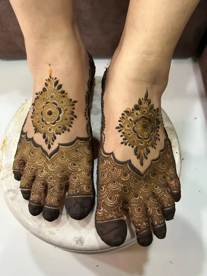 A classic foot mehendi design with a large central mandala and detailed patterns covering the toes.