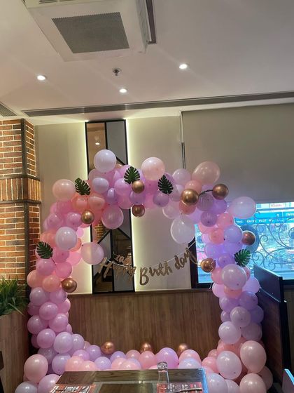 The pastel balloon arch seen from a different perspective, showing how it fits perfectly into the restaurant's booth seating area.