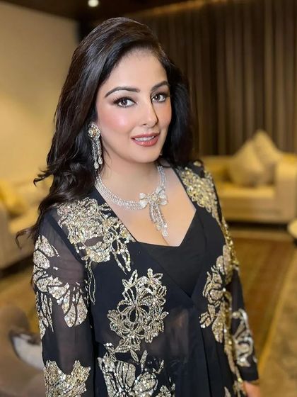 The full look, where the client's voluminous waves add a touch of classic glamour to her embroidered black outfit.