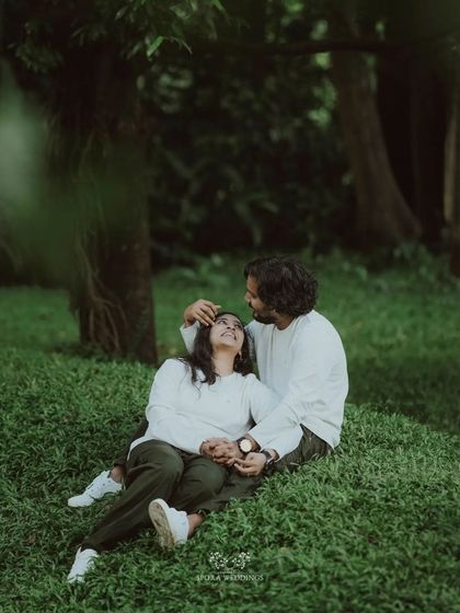 A tender moment with the couple relaxing on the grass, the groom gently stroking her hair.
