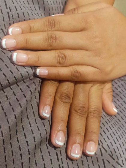 A perfect example of a classic French manicure on shorter, square-shaped natural nails. This style is always clean, professional, and effortlessly chic.