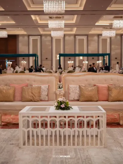 Elegant lounge seating for guests at the reception. The plush cream sofas with pastel cushions provide a comfortable and chic area for conversation.