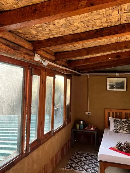 The cozy interior of one of the rooms at the Mukteshwar camp. Large windows let you feel connected to the surrounding forest.