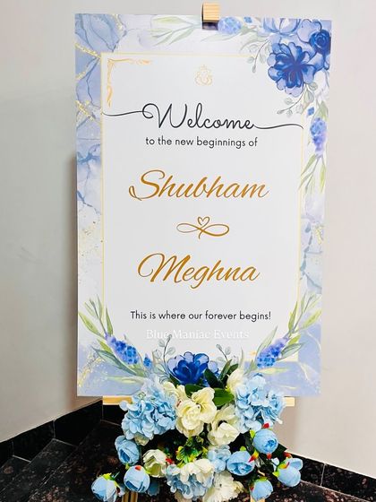 An elegant welcome sign for a Roka ceremony, designed with a blue floral and marble theme to match the couple's decor.