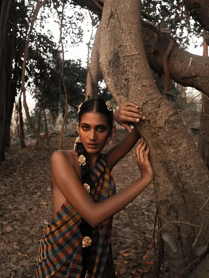 A portrait from the 'Divine' series where the model interacts with the natural environment. The earthy tones and soft light create a feeling of being one with nature.