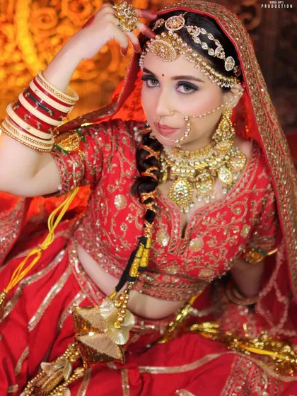 This dynamic pose highlights the different elements of a traditional bridal set. You can clearly see the intricate matha patti, the large nath, and the layered design of the kundan necklace.