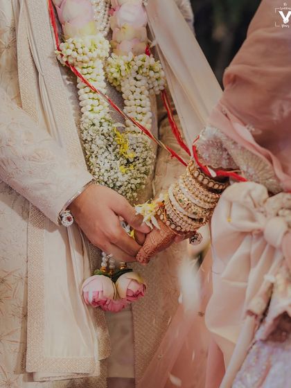A close-up shot of the couple holding hands during the ceremony. This intimate detail captures their connection and the symbolic gesture of their union.