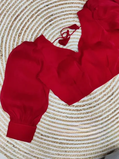 A bright red organza blouse with statement balloon sleeves.