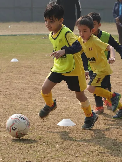Two young players in a 1v1 drill. This is where they learn to apply their skills under pressure, a core part of our philosophy of turning hard work into success.