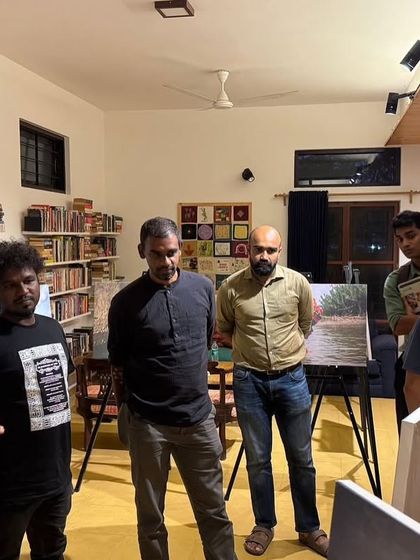 Visitors at the "Chronicles of the Tides" exhibition, listening to the stories behind the photographs.