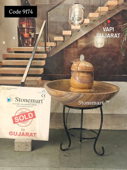 This tabletop fountain, sold to a client in Gujarat, is shown with its included metal stand. The stand elevates the piece, making it a perfect accent for a corner or entryway.
