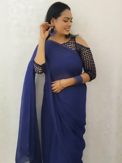 A candid and happy shot, showing off the cold-shoulder blouse and matching blue earrings.