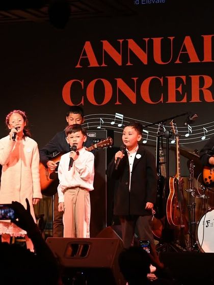 A full view of one of our student bands, featuring vocalists, guitarists, and a drummer. We help students form bands and prepare them for live gigs.