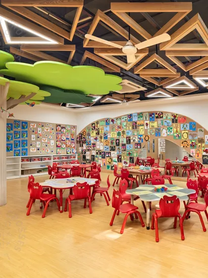 A vibrant classroom filled with children's artwork and featuring a nature-inspired ceiling design. We believe thoughtful design creates everyday experiences filled with warmth, connection, and a sense of quiet delight.
