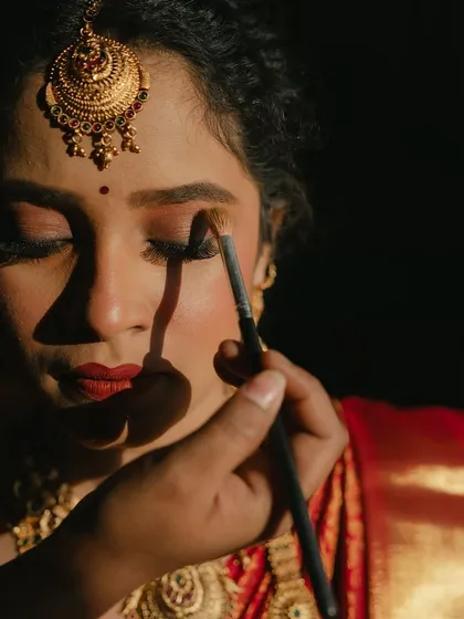 A behind-the-scenes look at the artistry. This shot shows the careful application of eyeshadow, a key step in creating her defined and captivating eyes.