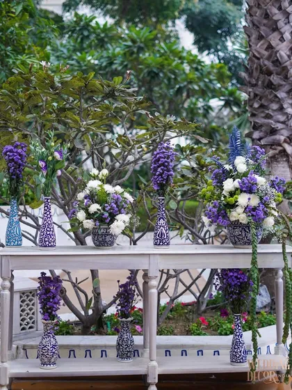 A console table displaying a variety of floral arrangements in blue and white patterned vases. This created a beautiful focal point in one of the garden areas.