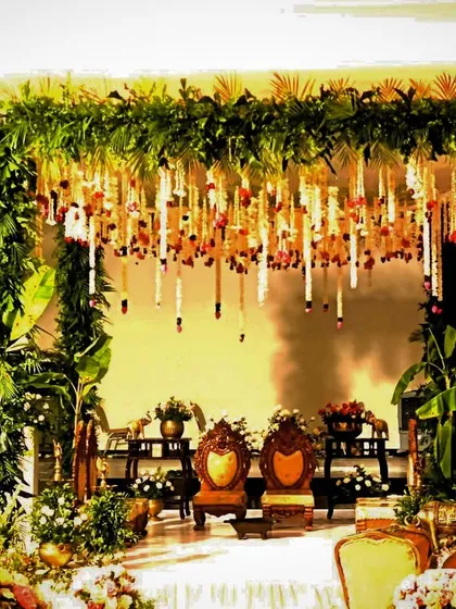 A classic South Indian mandap design, featuring a frame of lush greenery, hanging tuberose garlands, and auspicious banana trees. The traditional seating and brass elements complete this culturally rich and authentic wedding setup.