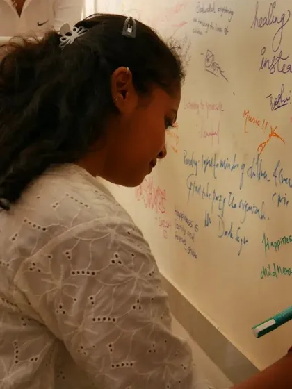 A volunteer writes on the "Happiness Wall," a tradition at our office bonding events.