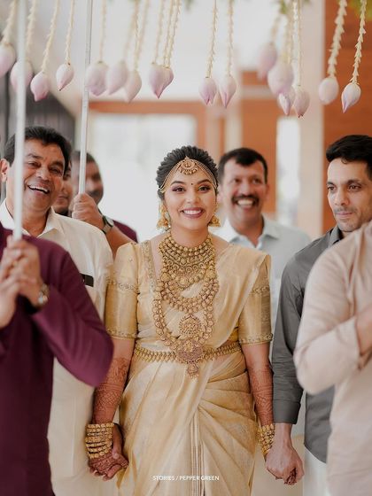 The radiant bride, Chaithanya, making her entrance under a canopy of lotus buds. This is a stunning example of how I capture the grand and beautiful moments of a bride's arrival.