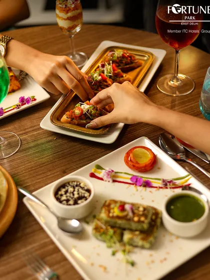 A close-up of guests sharing beautifully presented appetizers, including bruschetta and layered dessert shots.