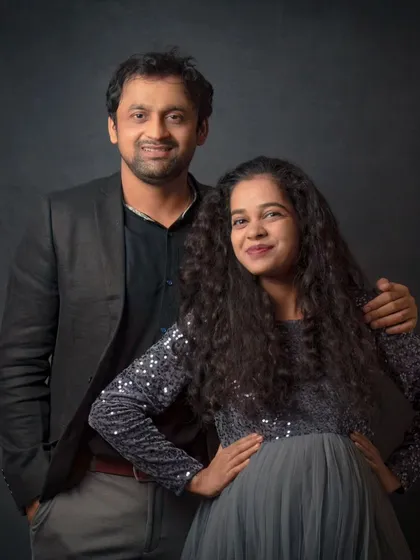A stylish couple's maternity portrait. The mom-to-be shines in a sequined dress, creating a glamorous and celebratory look.