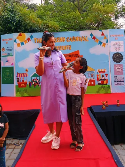 Connecting with the younger audience is one of my favorite parts of hosting family-friendly carnivals. Here I am sharing the mic with a confident young performer, making sure even the smallest stars get their moment to shine.