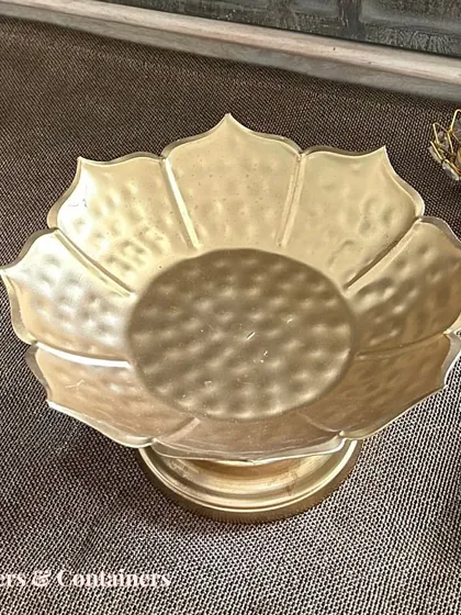 A golden lotus-shaped bowl on a stand, perfect for serving prasad or as a decorative piece in your pooja room.