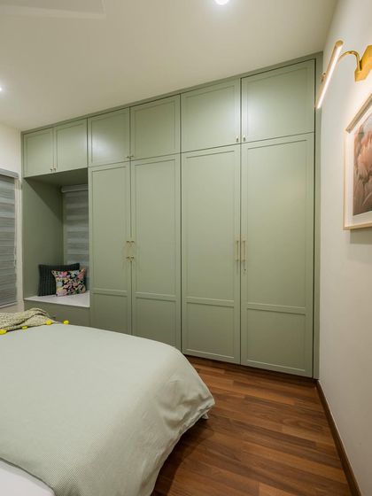 Another angle of the sage green bedroom, showing how the wardrobe design seamlessly integrates with the room's architecture.