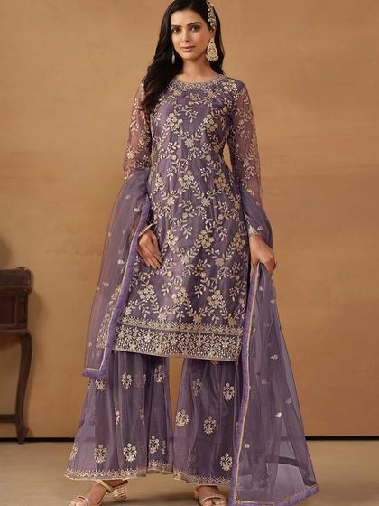This purple net salwar kameez with sharara pants is a festive dream. The all-over sequence and thread work make it sparkle from every angle.