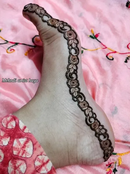 A clean and elegant floral vine design that traces the natural curve of the foot.