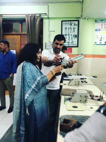 I believe in hands-on guidance. Here, I am showing a first-time shooter the correct way to handle an air pistol, ensuring she feels safe and confident from the very first moment.