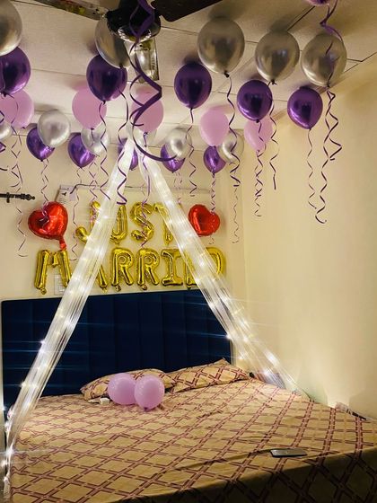 The combination of a lit canopy and ceiling balloons creates a magical and intimate atmosphere for a first night celebration.