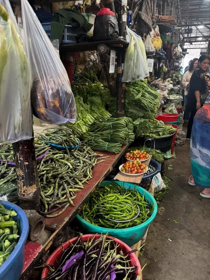 A stall at a Naga market piled high with fresh green beans, chillies, and bundles of leafy greens. The sheer variety and freshness is what makes our food so special.