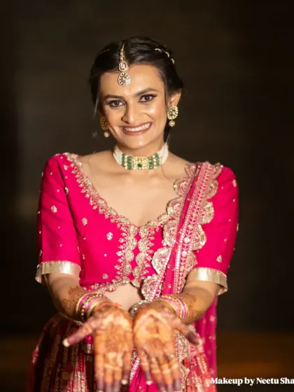 Showing off her beautiful henna. The bride's joyful expression and festive attire perfectly capture the spirit of a Garba night.