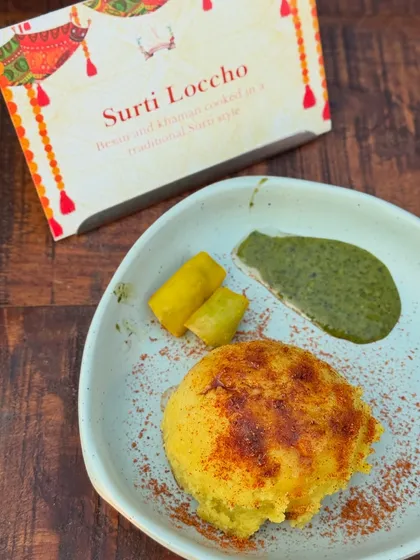 Surti Locho, a beloved savoury steamed snack from Gujarat, cooked in the traditional Khamni style. We take pride in perfecting regional delicacies to offer an authentic taste of home.