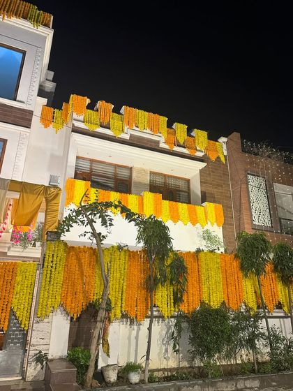 Another angle of the house decorated with marigold garlands, showing how we cover the balconies and entrance to create a complete festive look.