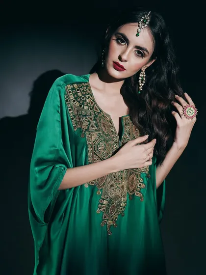 In this studio portrait, I used dramatic, low-key lighting to emphasize the luxurious feel of the emerald green kaftan. The focus is on the intricate gold embroidery and the model's commanding presence, creating a powerful image for a designer campaign.