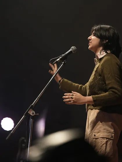 A dramatic shot of a poet performing under the stage lights at IIT Delhi. The atmosphere at these college shows is always electric.