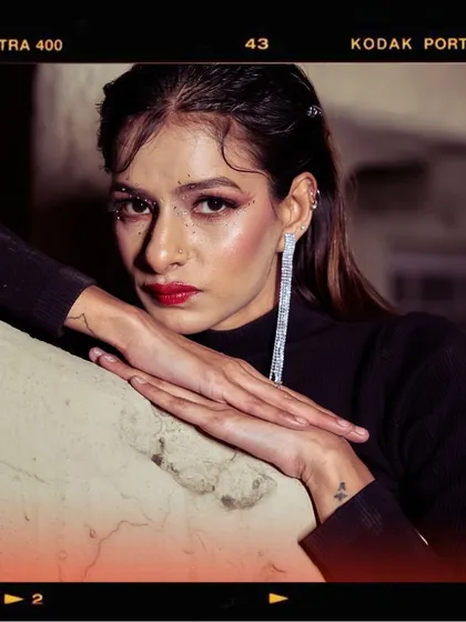 A powerful close-up portrait from the 'Embrace Self' shoot. The combination of bold red lipstick, dramatic earrings, and a confident gaze makes this a very strong image.