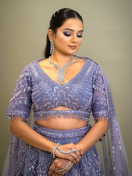 This bride looks absolutely stunning in a lavender lehenga. Her look is completed with a delicate zircon necklace and matching earrings, adding a touch of modern sparkle to her ensemble.