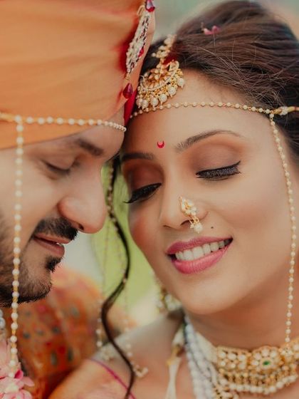An intimate close-up of a Maharashtrian couple, their eyes closed in a moment of serene connection. The intricate details of the bride's mundavalya and nath tell a story of tradition and love.