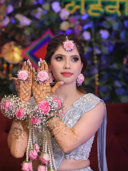Your Mehndi ceremony look should be as vibrant and joyful as the event itself. Here, we created a fresh, elegant look with soft pastel tones on the eyes and glowing skin, perfectly complementing the beautiful floral jewelry.