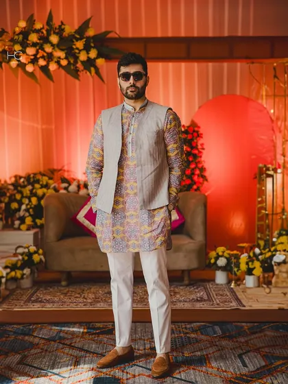 This full-length view shows how the printed kurta and solid bundi combination creates a sharp, celebratory outfit perfect for a sangeet or mehendi.