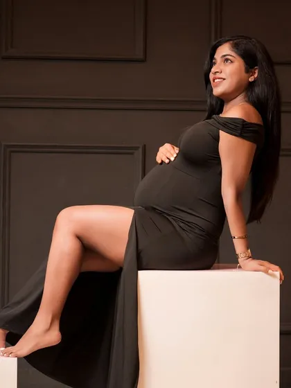 Sometimes, simplicity is the most powerful. This classic, elegant portrait in a simple black dress highlights the beautiful silhouette of motherhood against a dark, moody backdrop.