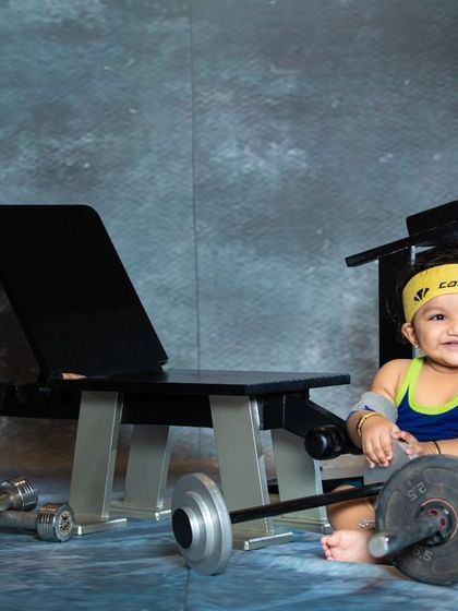 Starting them young! This little gym enthusiast is ready to pump some iron in our miniature gym setup.